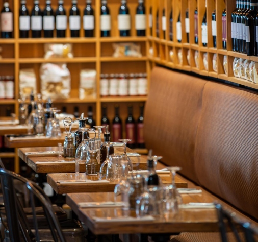 Agence M Com Marseille Fuxia Marseille Restaurant Epicerie Trattoria Italienne salle interieur restaurant tables dressees mur bouteilles vins italiens